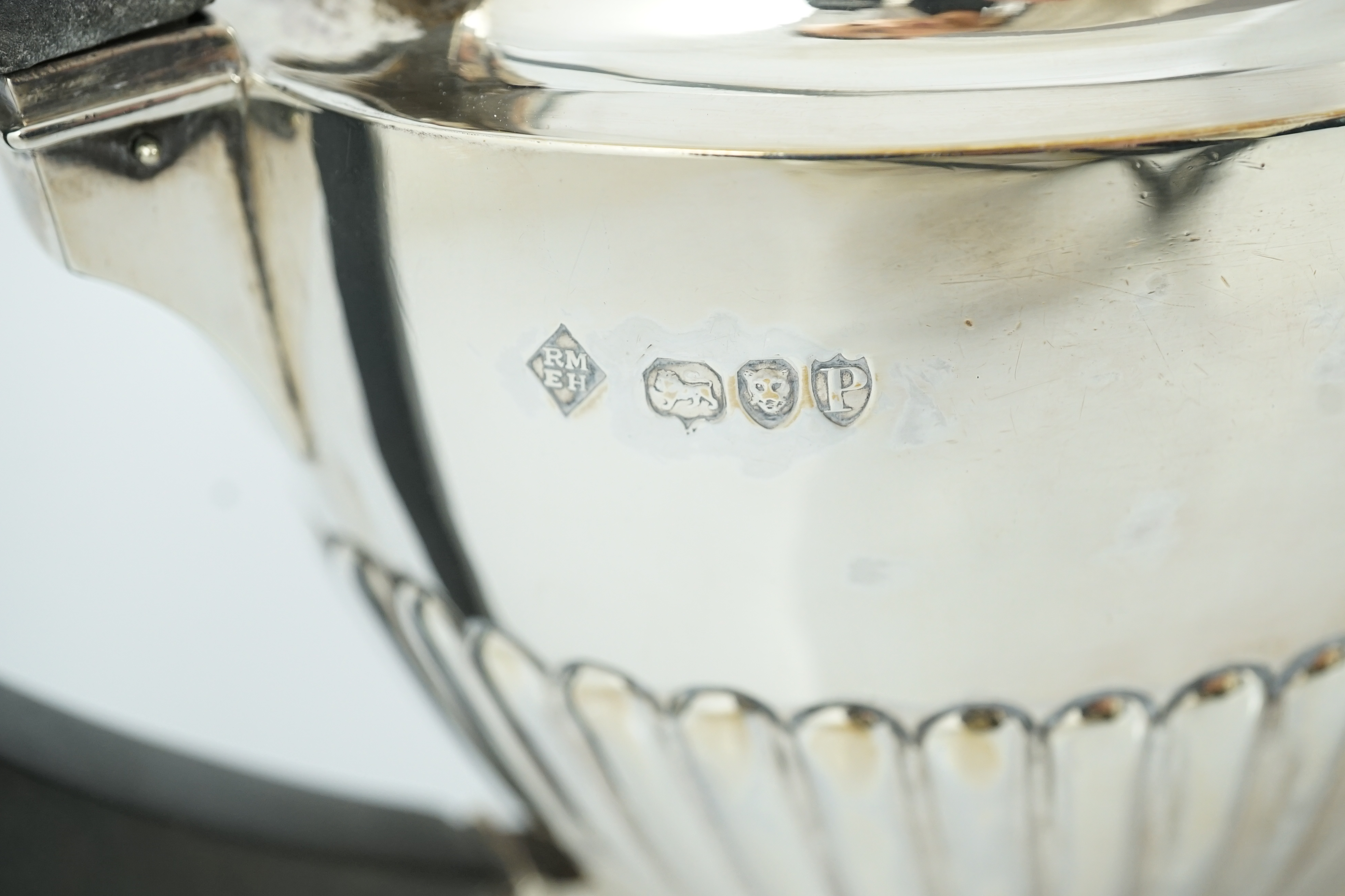 A late Victorian oak cased demi-fluted oval silver three piece tea set, by Martin, Hall & Co
